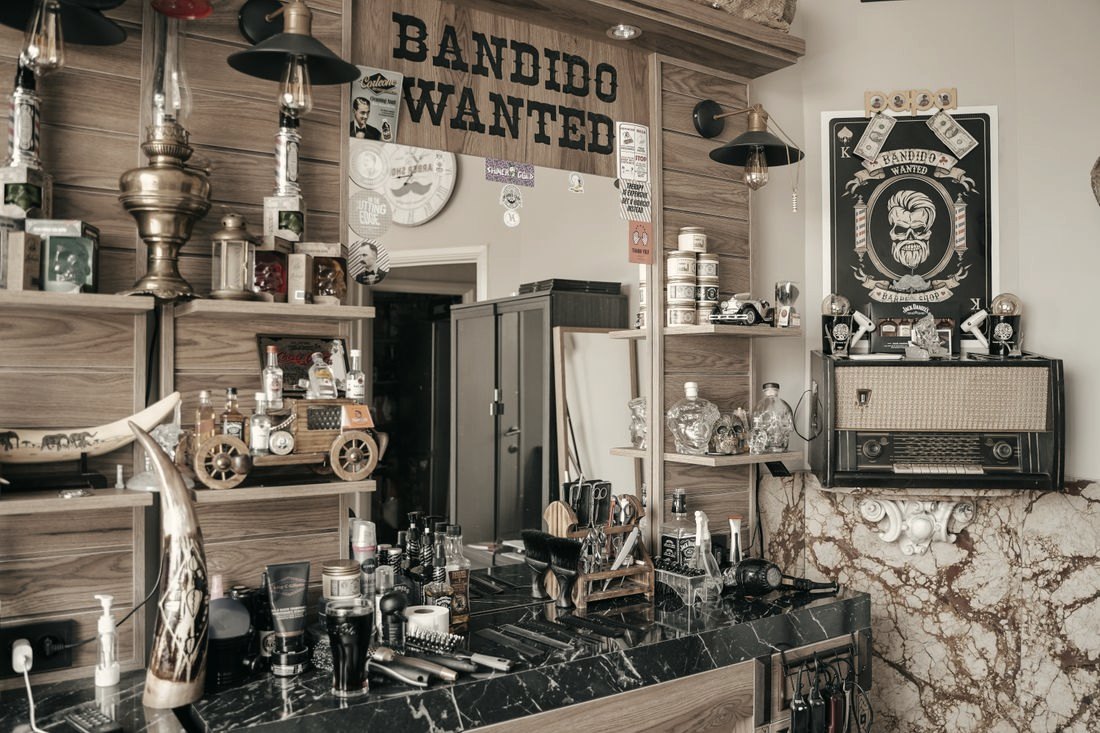 Bancada de barbearia com prateleiras de madeira e produtos