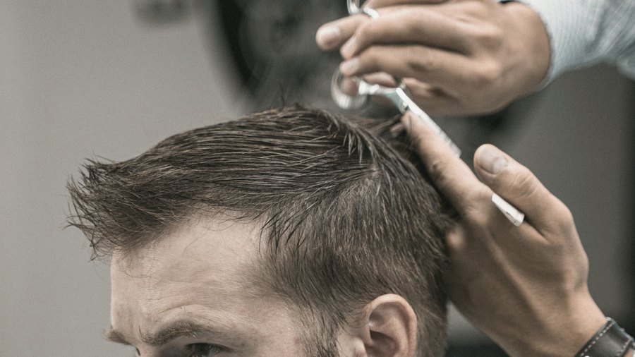 Barbeiro trabalhando no cabelo de um cliente