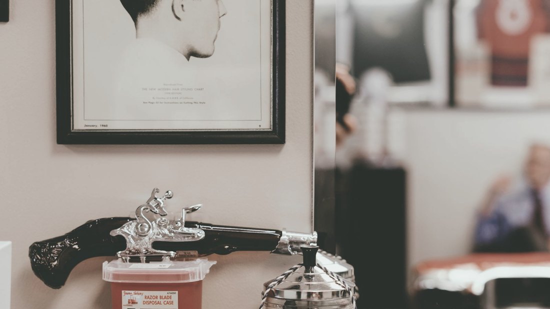 Produtos e pente de barbearia sobre bancada de madeira