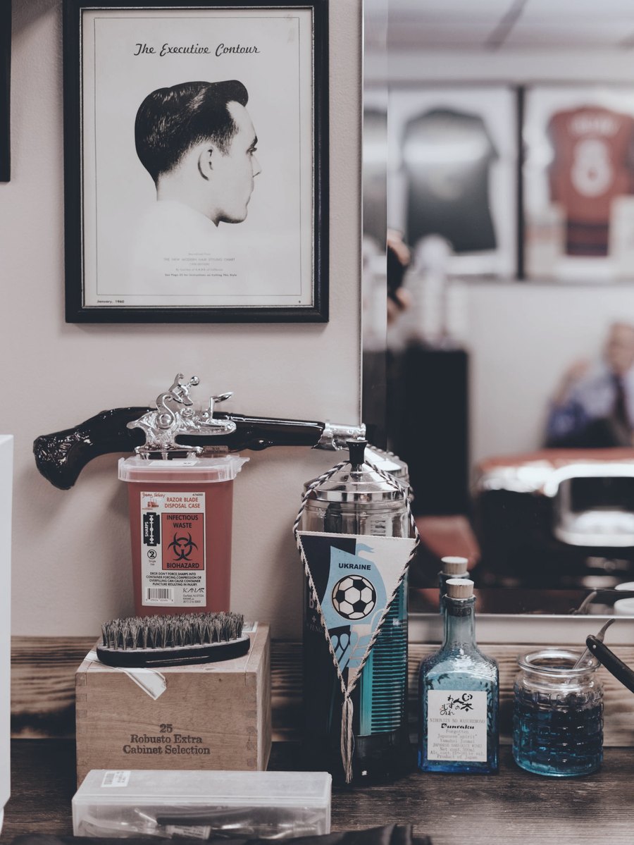 Pente e produtos de barbearia sobre a bancada