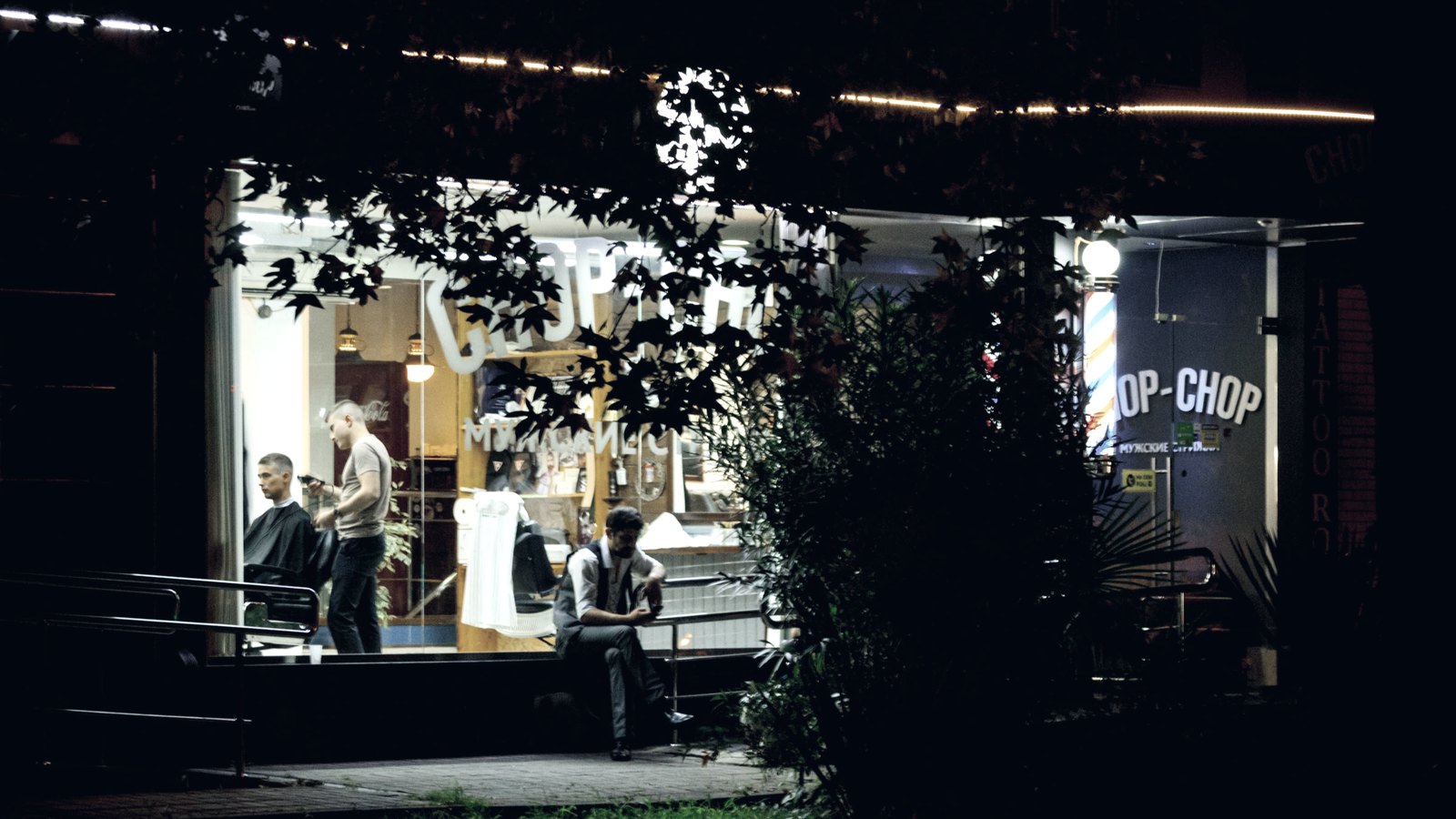 Barbearia iluminada à noite vista da vitrine