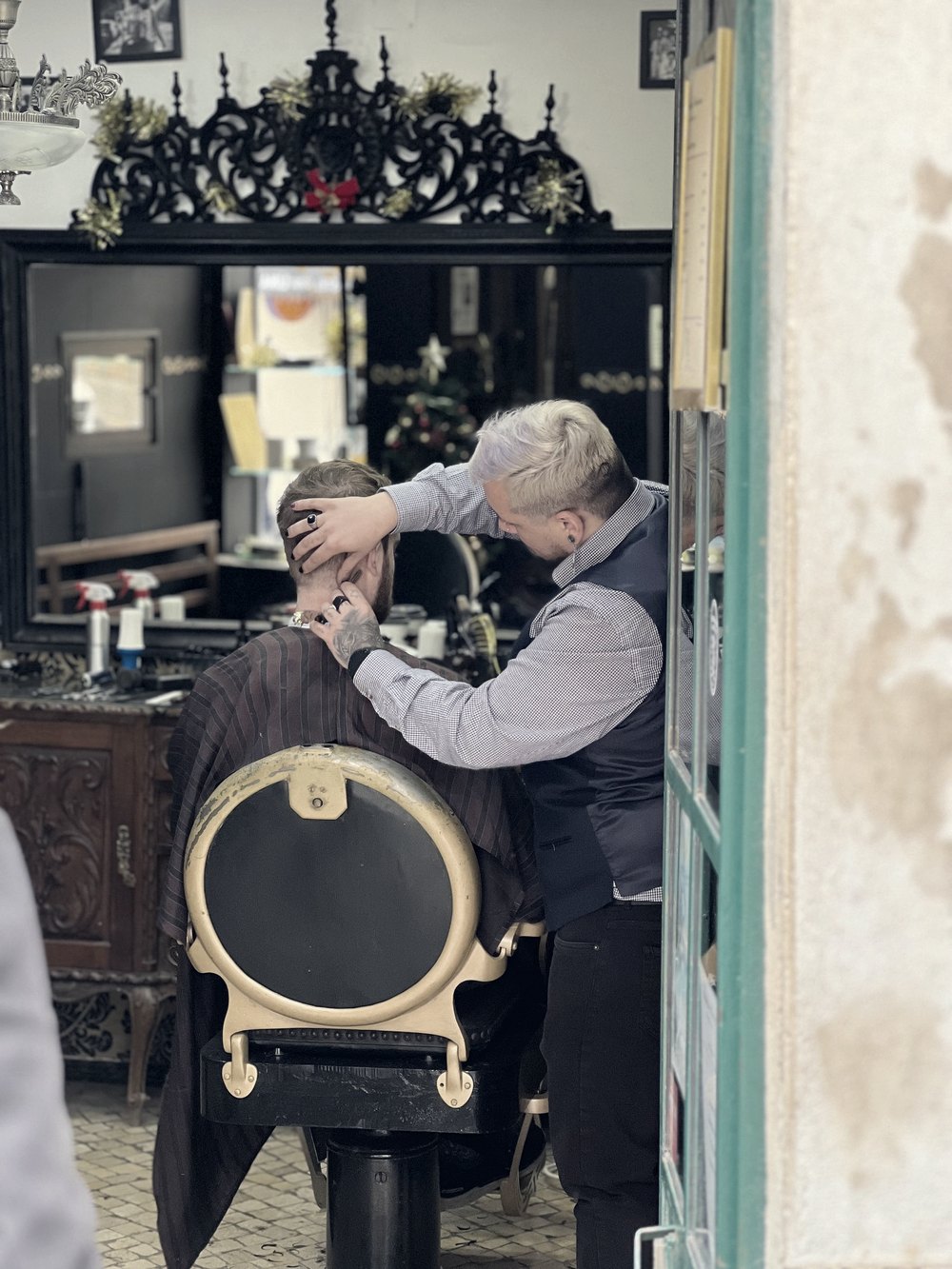 Barbeiro finalizando o corte de um cliente