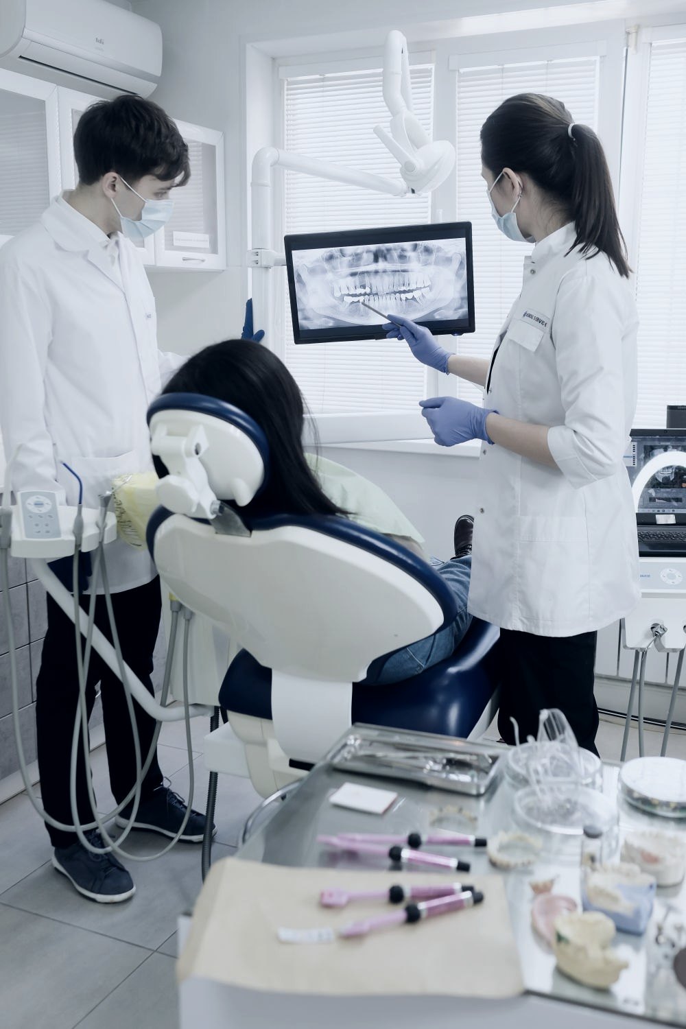 Profissionais analisando radiografia odontológica em tela