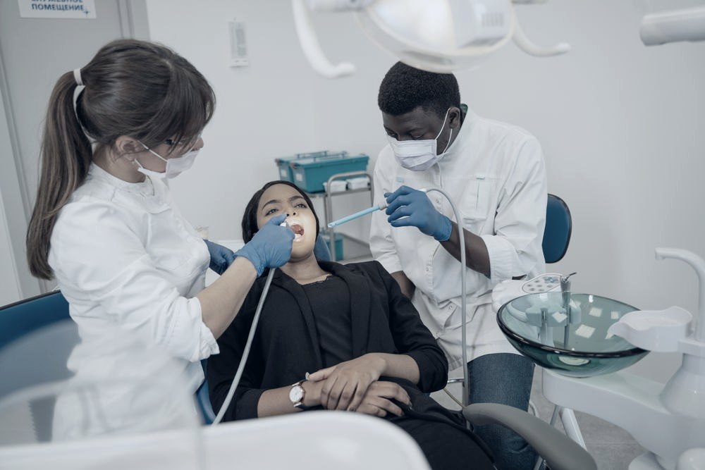 Equipe odontológica atendendo paciente na cadeira