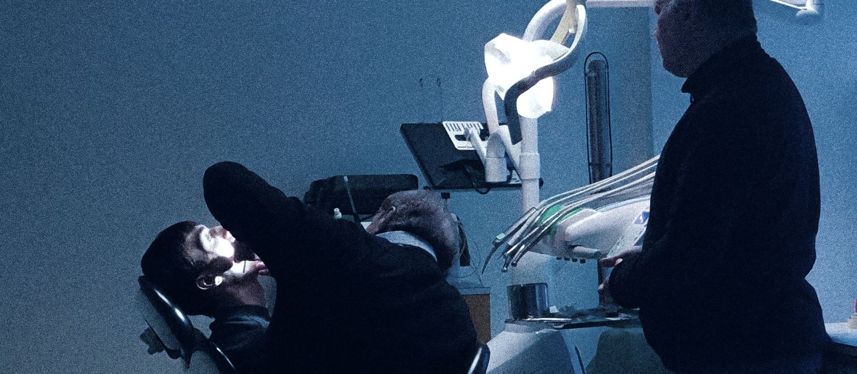 Atendimento noturno em consultório odontológico com iluminação baixa