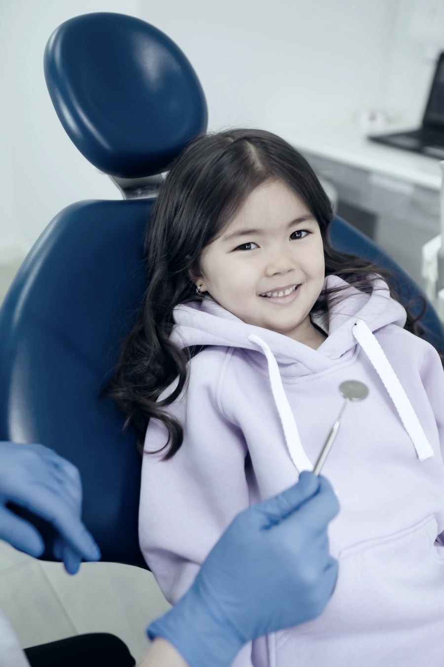 Menina sorrindo na cadeira do dentista
