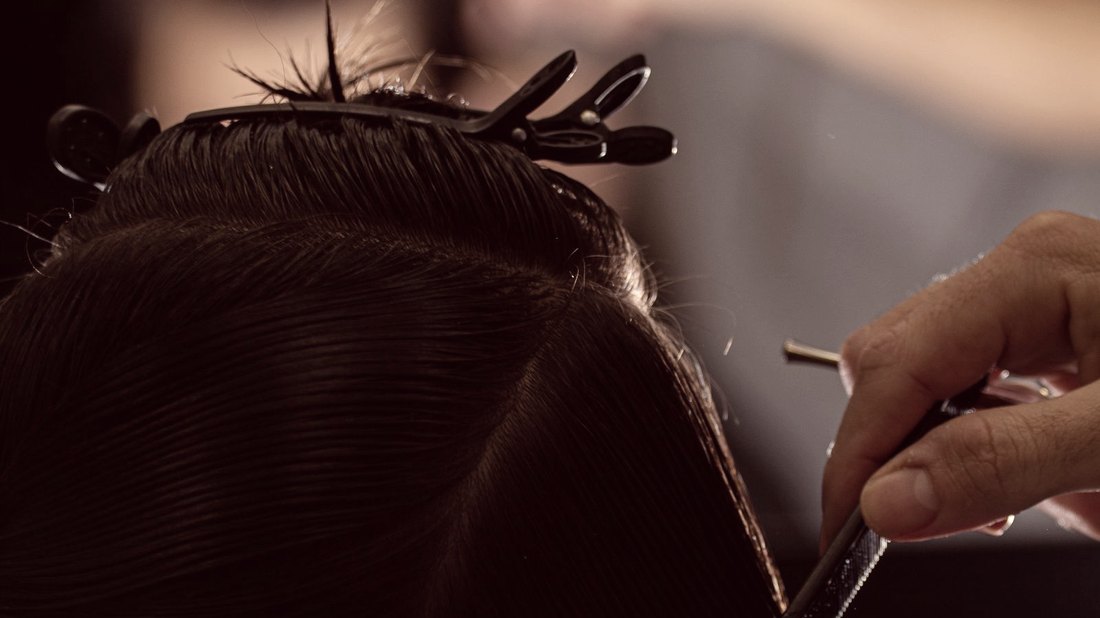 Profissional cortando o cabelo de uma cliente no salão