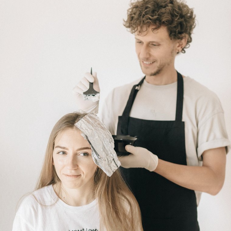 Aplicação de mechas com pincel no cabelo da cliente