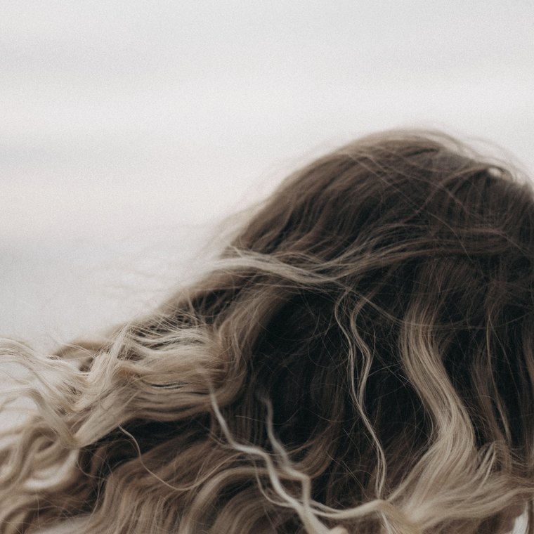 Detalhe de cabelo loiro iluminado ao vento