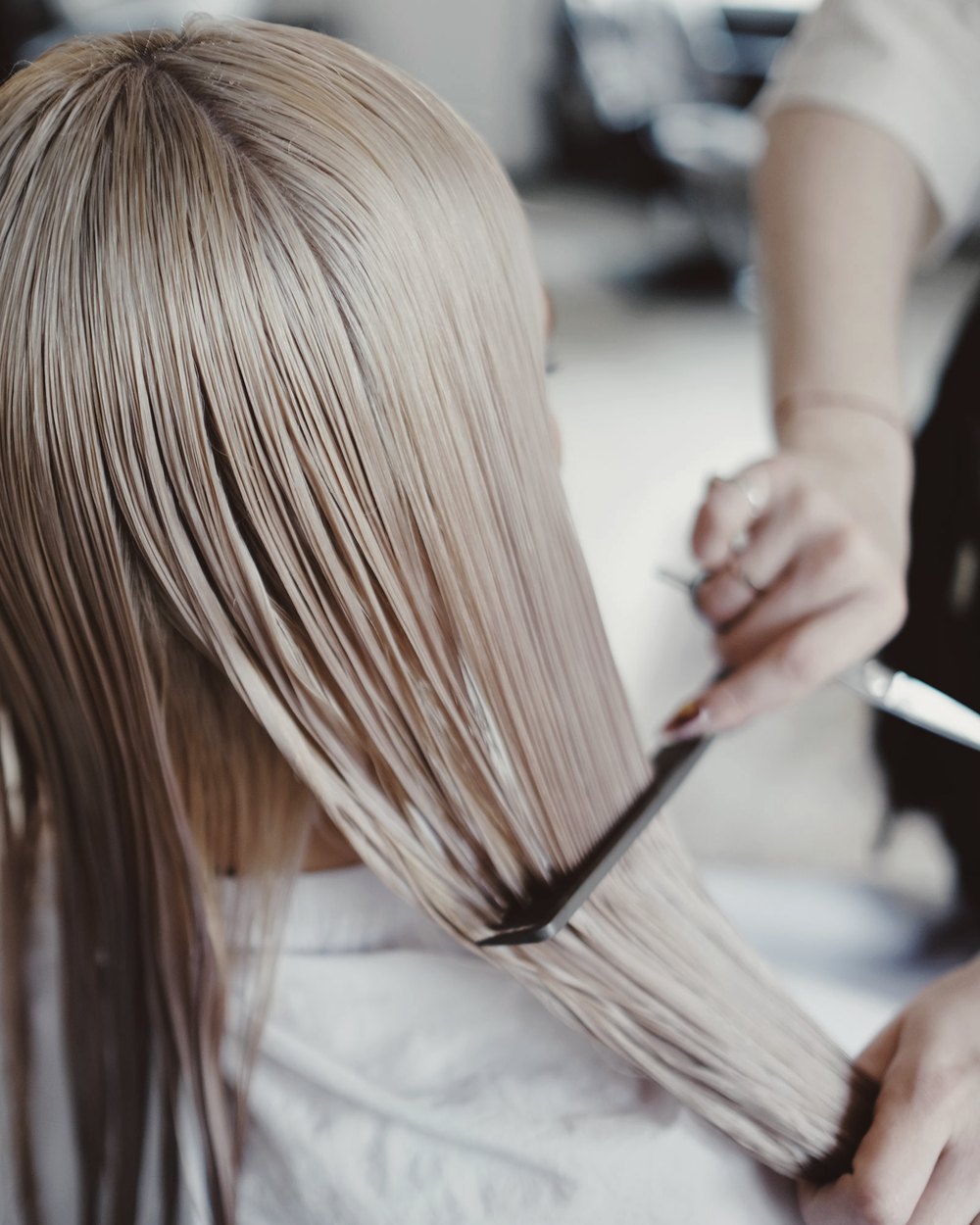 Cabelo loiro iluminado sendo finalizado no salão