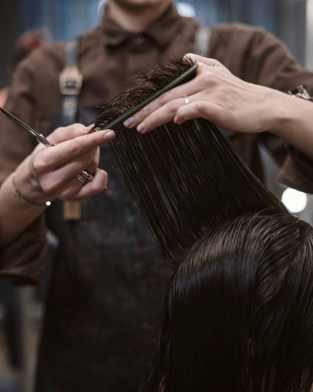 Profissional avaliando o cabelo de uma cliente no salão